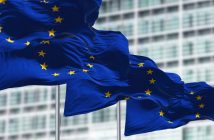 group of flags of the European Union waving in the wind